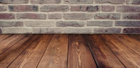 Stylish vintage brick wall background complemented by a rustic wooden floor.